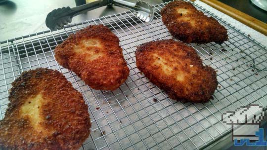 Fully cooked breaded pork chops waiting to be double cooked to make them extra crispy.