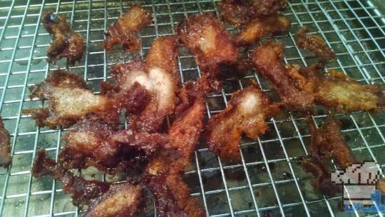 The crispy pork chips have been double fried and removed from the fryer to cool before eating.