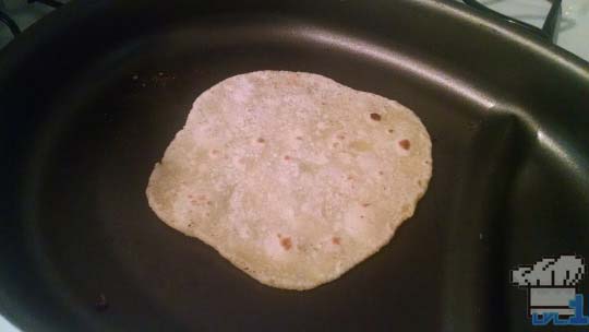 Roti bread cooking in pan.