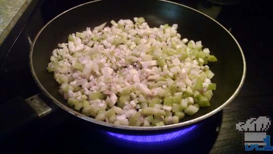Celery and onions being sauteed in a pan to soften them up.