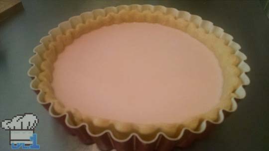 The custard is poured into the par-baked tart shell and left to cool and set before peach slice assembly.