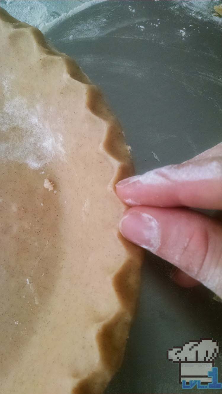 Pinching the edges of the pie dough crust.