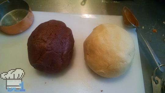 Chocolate cookie dough and vanilla cookie dough rolled into a ball for checkerboard cookies.