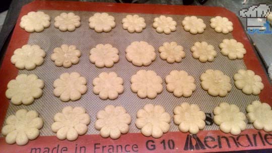 Baked flower cookies on pan, ready to be decorated.