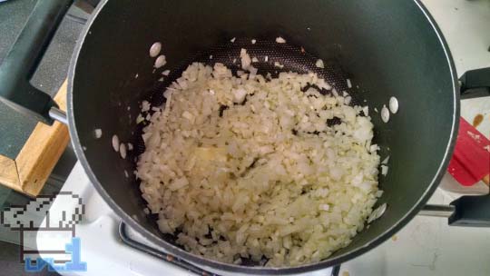 Chopped onions sauteeing in a pan until they are tender and soft.