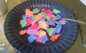 Torn up pieces of colorful construction paper on a plate as a joke Temflakes recipe from the Undertale game series.