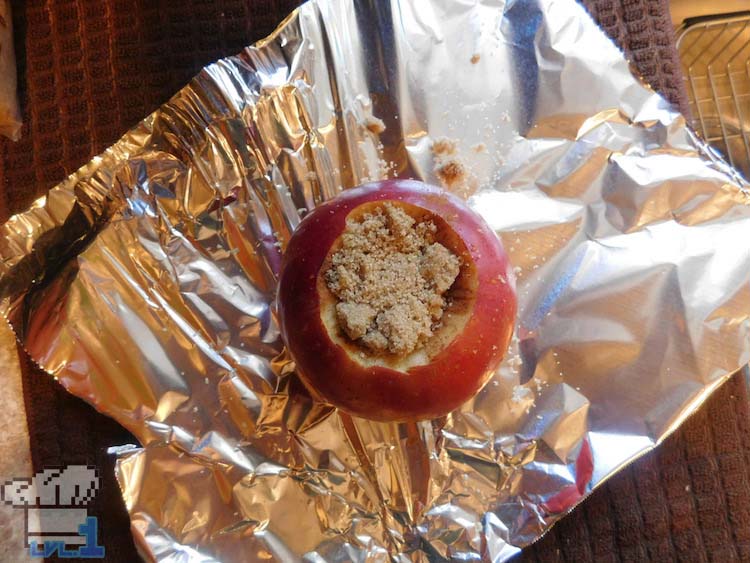 Cored and stuffed apple with cinnamon and brown sugar, waiting to be wrapped in foil and baked.