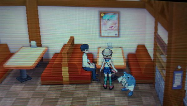 A screenshot from the Pokemon game series of a big malasada poster in the bakery.