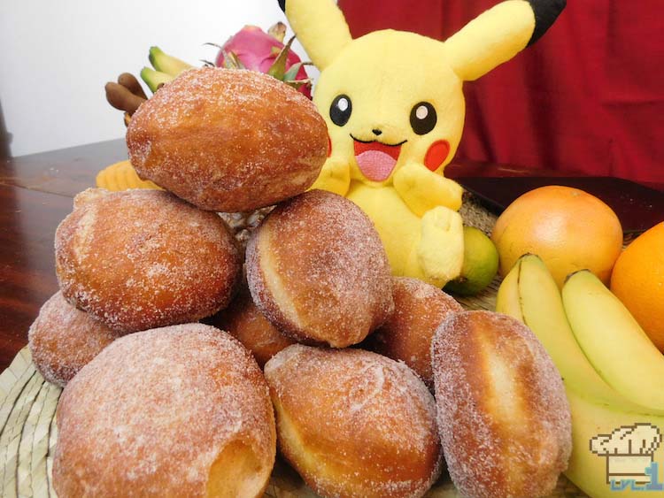 A hungry Pikachu is looking at the mound of sugared malasada doughnuts from the Pokemon game series.
